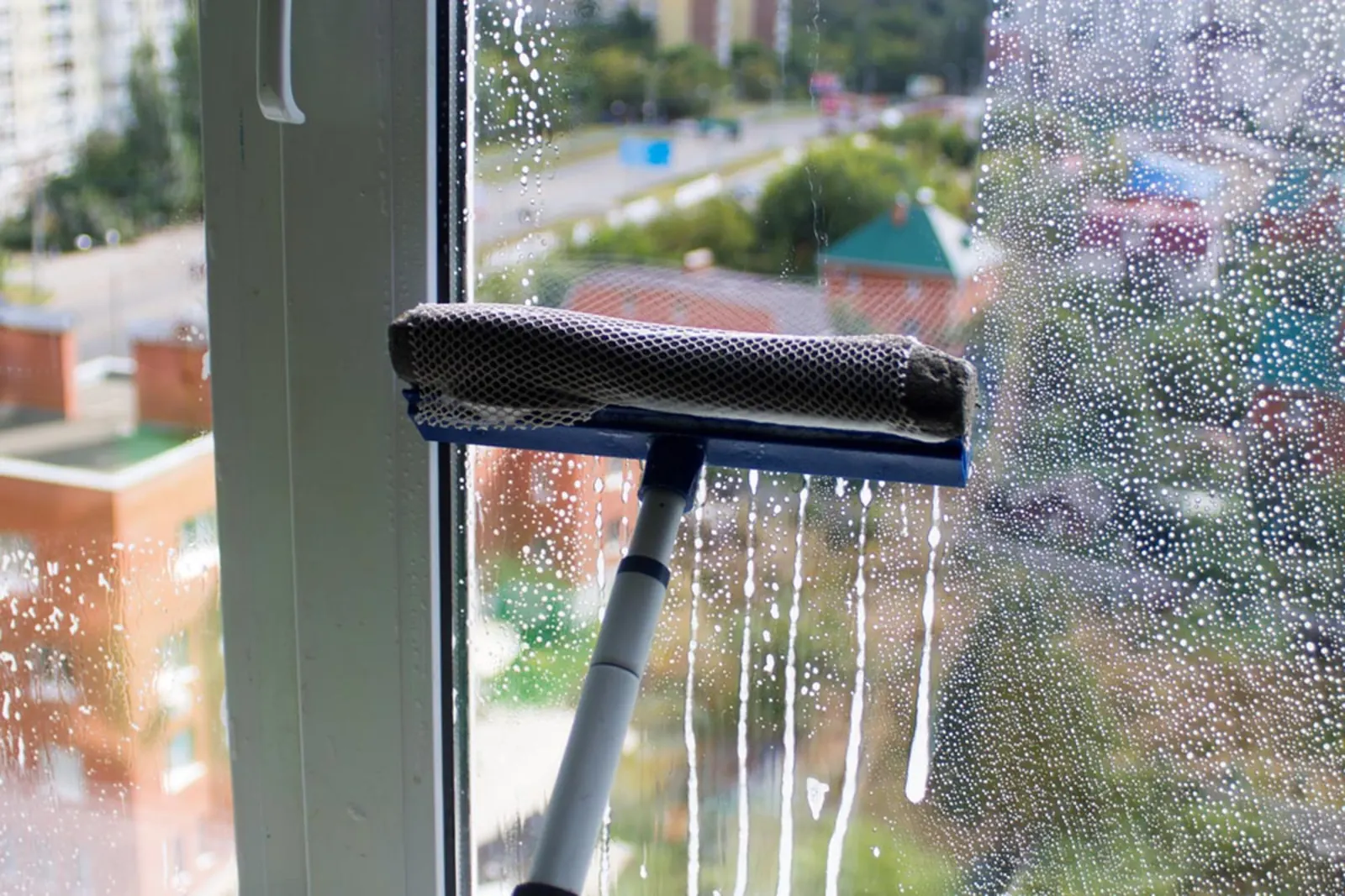Professional window cleaner squeegeeing a Los Angeles home window